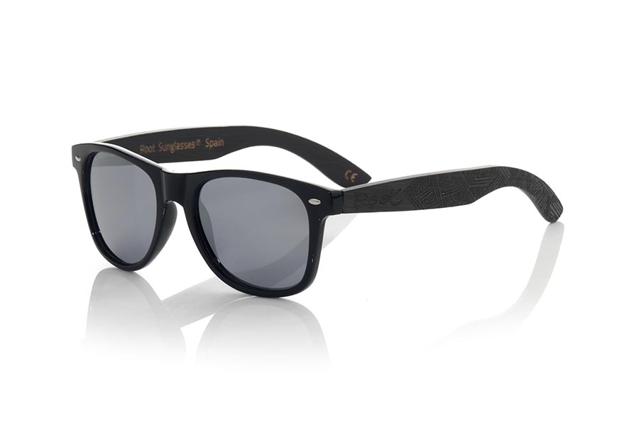 Wood eyewear of Bambú SKA BLACK. The Ska black sunglasses are made with the black glossy PC front and the black tinted natural bamboo wood sideburns engraved with an ethnic pattern, combined with various colors of lenses that suit your style. Frontal measurement: 148x50mm for Wholesale & Retail | Root Sunglasses® 