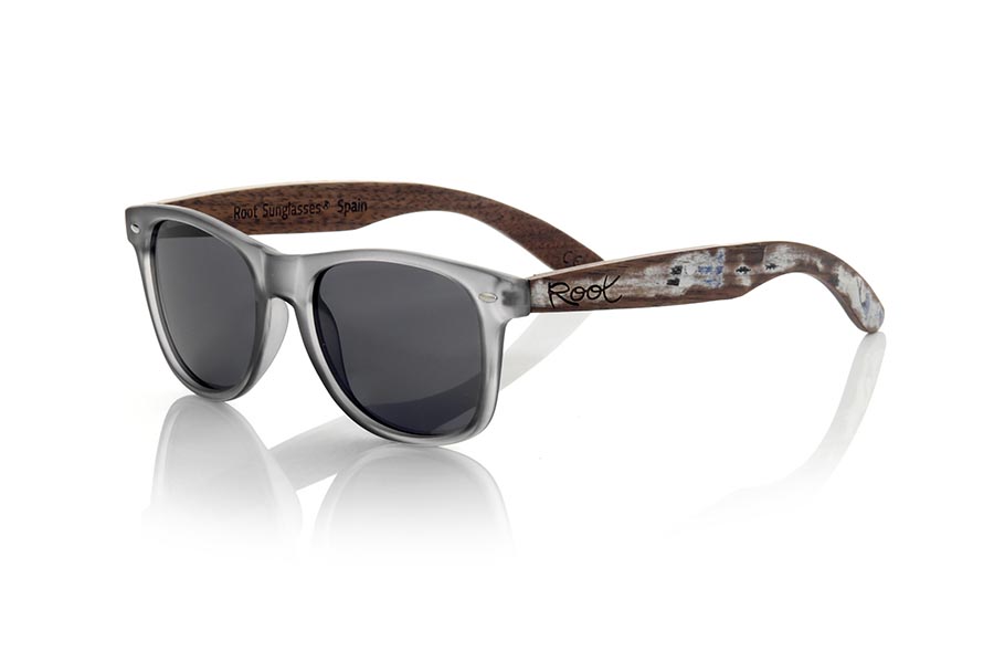 Wood eyewear of Walnut SKA GREY. The Ska grey sunglasses are made with a matt transparent grey PC front and natural walnut vintage effect wood sideburns, combined with various colors of lenses that suit your style. Front measurement: 148x50mm * Note the vintage effect is a stripping technique whose result varies from one model to another so the pattern can vary from one model to another, and may not exactly match the displayed images what makes each of the goggles unique. for Wholesale & Retail | Root Sunglasses® 