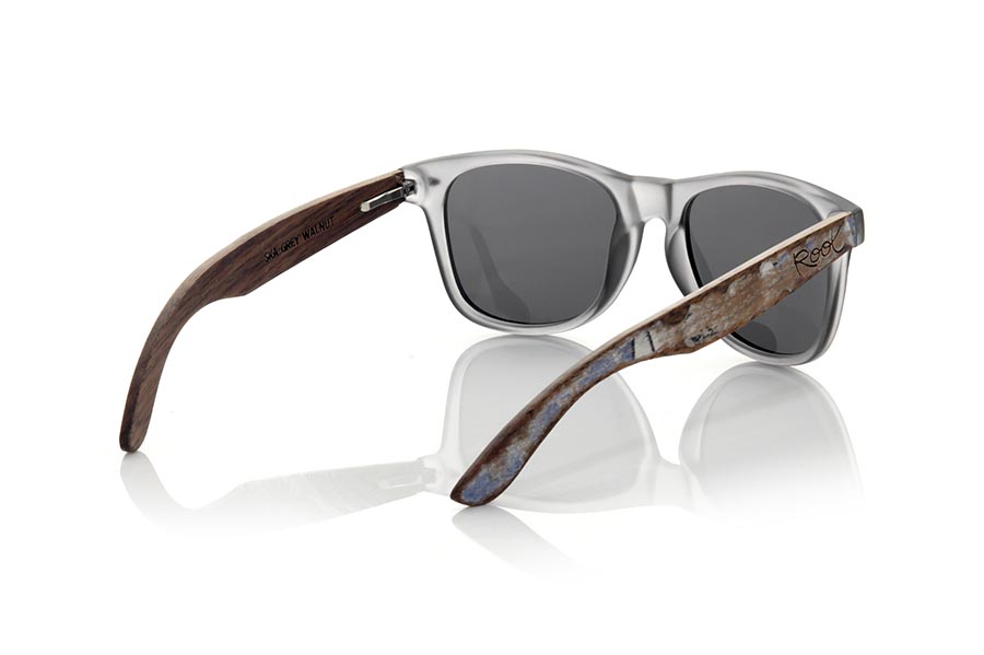 Wood eyewear of Walnut SKA GREY. The Ska grey sunglasses are made with a matt transparent grey PC front and natural walnut vintage effect wood sideburns, combined with various colors of lenses that suit your style. Front measurement: 148x50mm * Note the vintage effect is a stripping technique whose result varies from one model to another so the pattern can vary from one model to another, and may not exactly match the displayed images what makes each of the goggles unique. for Wholesale & Retail | Root Sunglasses® 