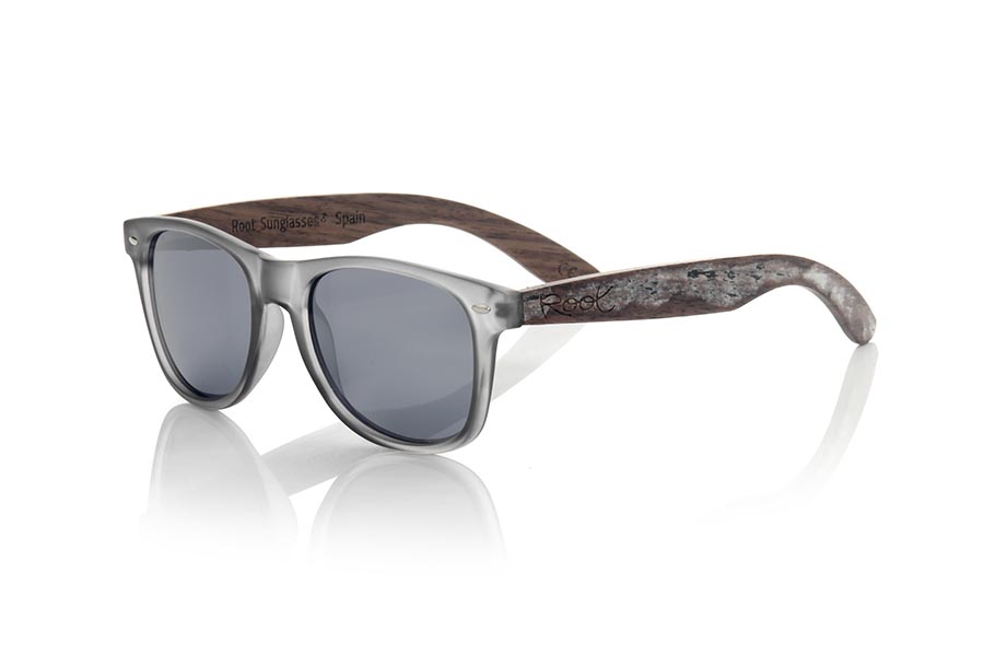 Wood eyewear of Walnut SKA GREY. The Ska grey sunglasses are made with a matt transparent grey PC front and natural walnut vintage effect wood sideburns, combined with various colors of lenses that suit your style. Front measurement: 148x50mm * Note the vintage effect is a stripping technique whose result varies from one model to another so the pattern can vary from one model to another, and may not exactly match the displayed images what makes each of the goggles unique. for Wholesale & Retail | Root Sunglasses® 