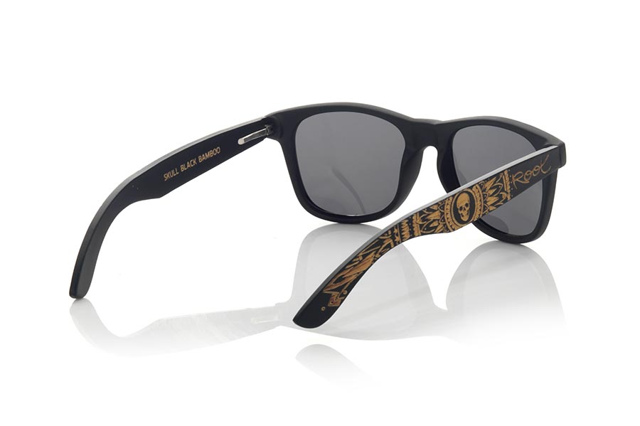 Wood eyewear of Bamboo SKULL BLACK. The skull black sunglasses are made with the black Matt PC front and the natural bamboo wood sideburns engraved with an ethnic skull design, combined with various colors of lenses that suit your style. Frontal measurement: 148x50mm. Caliber: 53 for Wholesale & Retail | Root Sunglasses® 