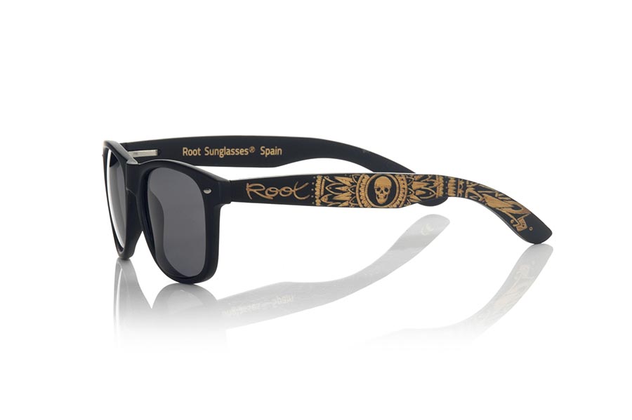 Wood eyewear of Bambú SKULL BLACK. The skull black sunglasses are made with the black Matt PC front and the natural bamboo wood sideburns engraved with an ethnic skull design, combined with various colors of lenses that suit your style. Frontal measurement: 148x50mm. Caliber: 53 for Wholesale & Retail | Root Sunglasses® 