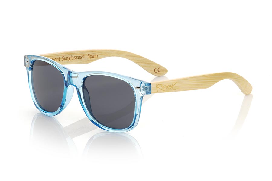 Wood eyewear of Bamboo CANDY BLUE DS. The Candy BLUE DS sunglasses are made with the front in transparent glossy clear Blue synthetic material and natural bamboo wood sideburns combined with four colors of lenses that will allow you to adapt them to your style. Frontal measurement: 148x50mm for Wholesale & Retail | Root Sunglasses® 