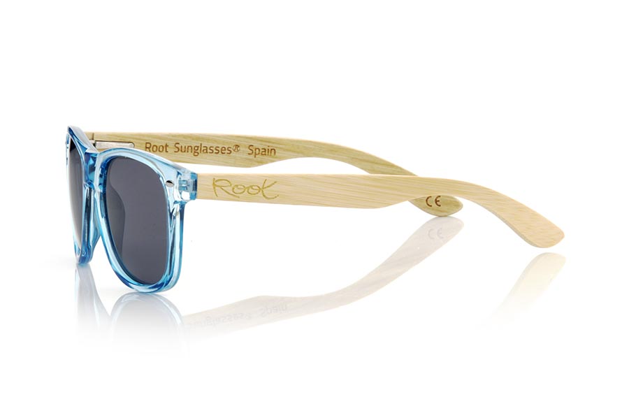 Wood eyewear of Bamboo CANDY BLUE DS. The Candy BLUE DS sunglasses are made with the front in transparent glossy clear Blue synthetic material and natural bamboo wood sideburns combined with four colors of lenses that will allow you to adapt them to your style. Frontal measurement: 148x50mm for Wholesale & Retail | Root Sunglasses® 