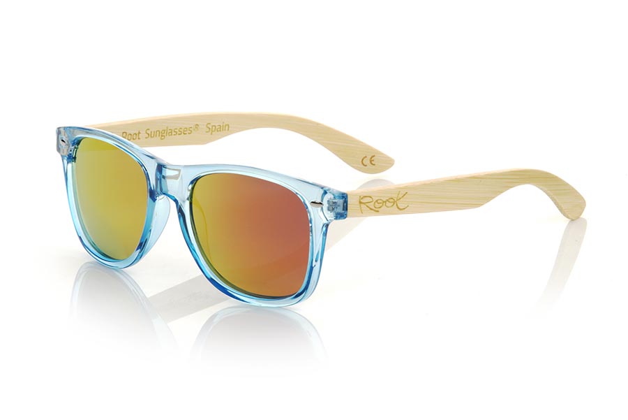 Wood eyewear of Bambú modelo CANDY BLUE DS. The Candy BLUE DS sunglasses are made with the front in transparent glossy clear Blue synthetic material and natural bamboo wood sideburns combined with four colors of lenses that will allow you to adapt them to your style. Frontal measurement: 148x50mm | Root Sunglasses® 