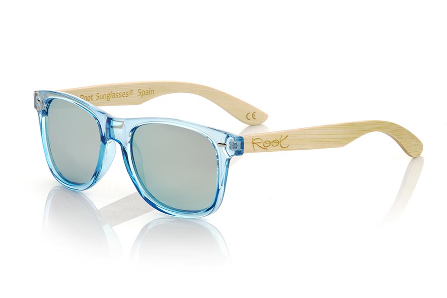 Wood eyewear of Bambú modelo CANDY BLUE DS. The Candy BLUE DS sunglasses are made with the front in transparent glossy clear Blue synthetic material and natural bamboo wood sideburns combined with four colors of lenses that will allow you to adapt them to your style. Frontal measurement: 148x50mm | Root Sunglasses® 