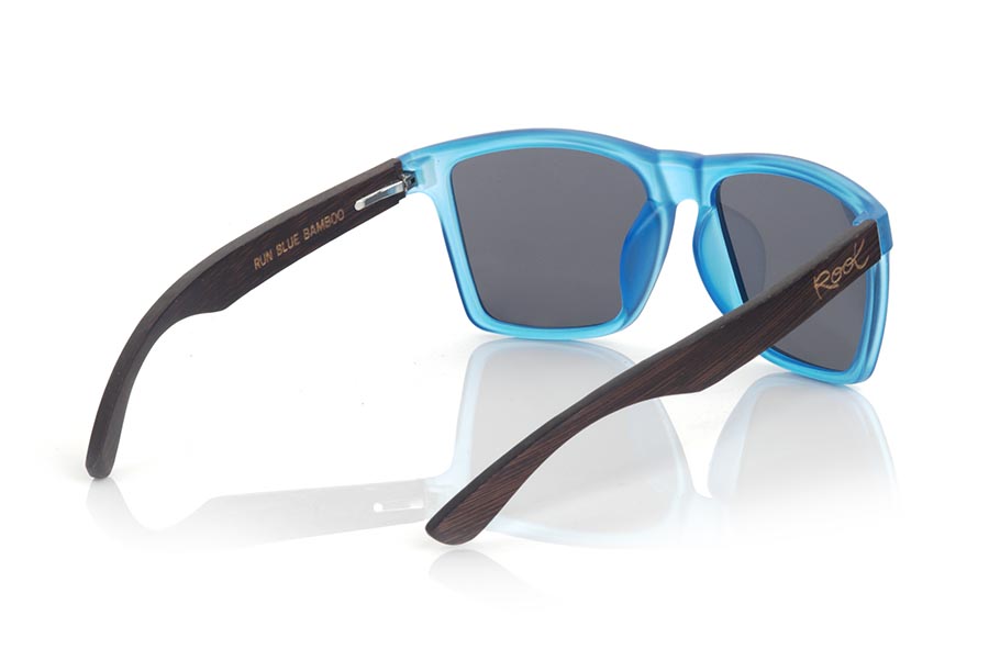 Gafas de Madera Natural de Bambú RUN BLUE DS. Las gafas de sol RUN BLUE DS están realizadas con el frontal de material sintético mate transparente azul y las varillas en madera de BAMBÚ tintado marrón, se trata de un modelo cuadrado anguloso muy masculino con un aire a las famosas okley combinadas con cuatro colores de lentes que se adaptarán a la perfección a tu gusto y a tu estilo moderno. Medida frontal: 144X51mm Venta al Por Mayor y Detalle | Root Sunglasses® 