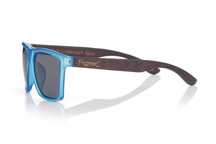 Wood eyewear of Bamboo RUN BLUE DS. RUN BLUE DS sunglasses are made with the front of transparent matte synthetic blue material and sideburns in brown stained bamboo wood, it is a very male angled square model with a look at the famous okley combined with four colors of lenses that will adapt perfectly to your taste and to your modern style. Front size: 144X51mm for Wholesale & Retail | Root Sunglasses® 