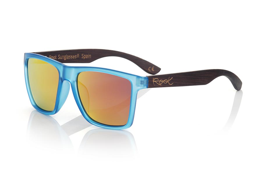 Wood eyewear of Bambú modelo RUN BLUE DS. RUN BLUE DS sunglasses are made with the front of transparent matte synthetic blue material and sideburns in brown stained bamboo wood, it is a very male angled square model with a look at the famous okley combined with four colors of lenses that will adapt perfectly to your taste and to your modern style. Front size: 144X51mm | Root Sunglasses®