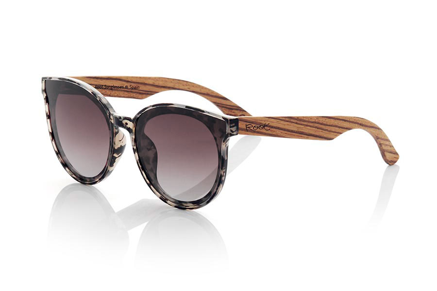 Wood eyewear of Walnut modelo INTHIRA. INTHIRA sunglasses are made with the front in transparent CAREY colored PC material in shades of black, white and brown tones and the temples in Natural WALNUT wood. Female model with rounded shapes that fits well, the INTHIRA glasses Approx front measurement: 142x55mm | Root Sunglasses® 