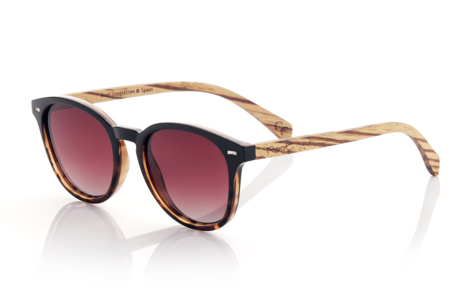 Wood eyewear of Walnut modelo RUSCH. RUSCH glasses are the perfect choice for those looking for an elegant and timeless style. With a two-tone black and black tortoiseshell front, these glasses have a distinctive touch that makes them unique. The walnut wood temples add a touch of warmth and naturalness to its design. This rounded model is unisex and adapts to any face shape, making it perfect for anyone. In addition, the gradient lenses give them a very special touch and provide total protection against UV rays and sunlight, which makes them an excellent option for any outdoor activity. Front Measurement: | Root Sunglasses® 