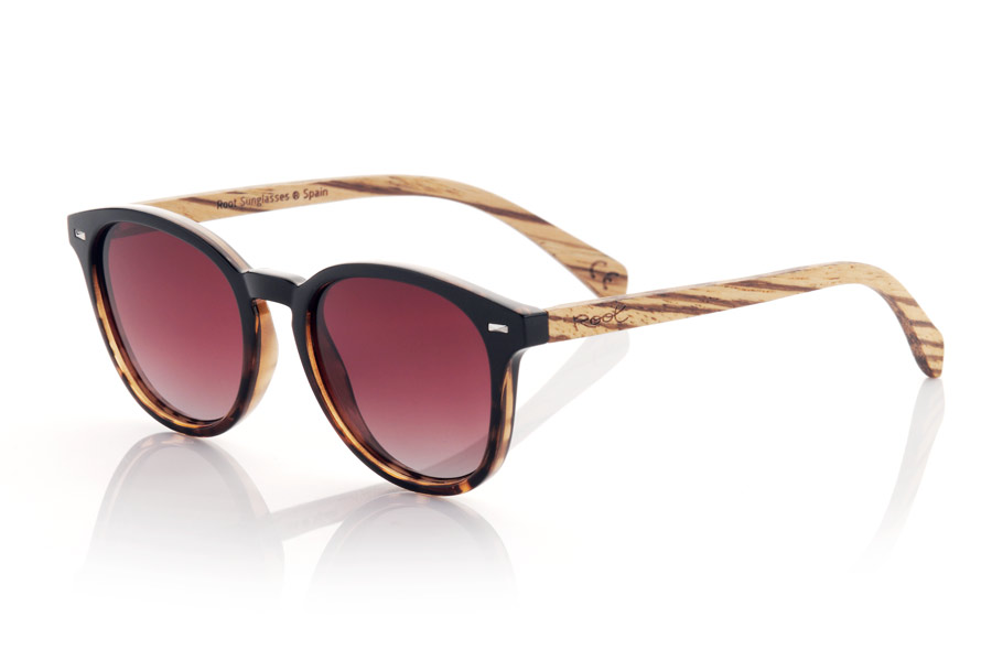 Gafas de Madera Natural de Walnut modelo RUSCH. Las gafas RUSCH son la elección perfecta para aquellos que buscan un estilo elegante y atemporal. Con un frontal bicolor negro y negro carey, estas gafas tienen un toque distintivo que las hace únicas. Las varillas de madera de nogal añaden un toque de calidez y naturalidad a su diseño. Este modelo redondeado es unisex y se adapta a cualquier forma de cara, haciéndolo perfecto para cualquier persona. Además, las lentes degradadas les dan toque muy especial y brindan protección total contra los rayos UV y la luz del sol, lo que las convierte en una excelente opción para cualquier actividad al aire libre. Medida Frontal:  | Root Sunglasses® 