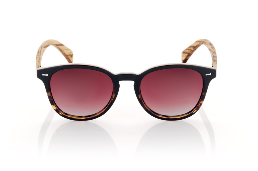 Wood eyewear of Walnut RUSCH. RUSCH glasses are the perfect choice for those looking for an elegant and timeless style. With a two-tone black and black tortoiseshell front, these glasses have a distinctive touch that makes them unique. The walnut wood temples add a touch of warmth and naturalness to its design. This rounded model is unisex and adapts to any face shape, making it perfect for anyone. In addition, the gradient lenses give them a very special touch and provide total protection against UV rays and sunlight, which makes them an excellent option for any outdoor activity. Front Measurement: for Wholesale & Retail | Root Sunglasses® 