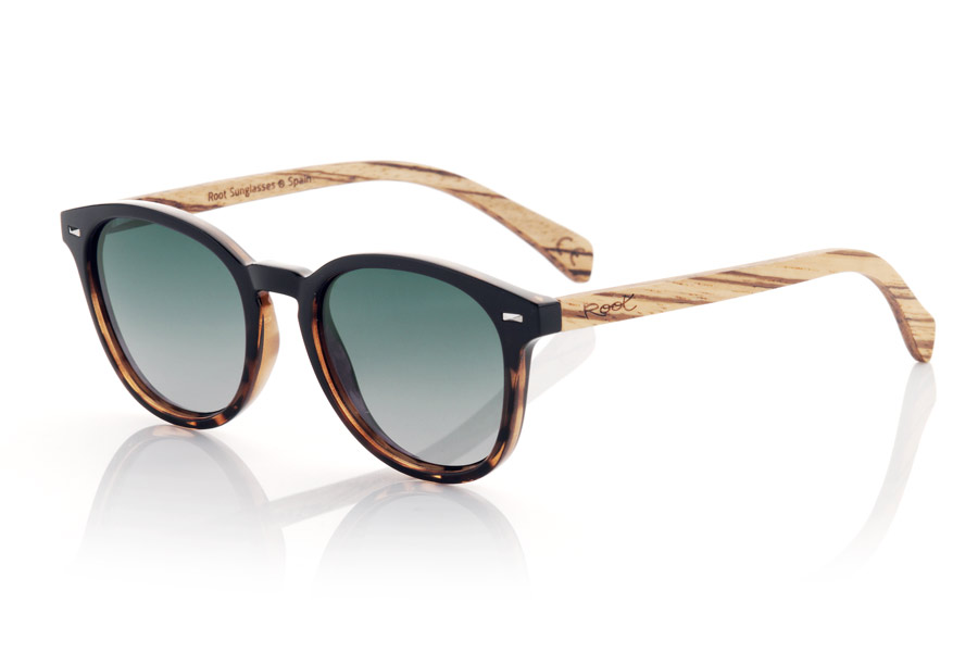 Wood eyewear of Walnut RUSCH. RUSCH glasses are the perfect choice for those looking for an elegant and timeless style. With a two-tone black and black tortoiseshell front, these glasses have a distinctive touch that makes them unique. The walnut wood temples add a touch of warmth and naturalness to its design. This rounded model is unisex and adapts to any face shape, making it perfect for anyone. In addition, the gradient lenses give them a very special touch and provide total protection against UV rays and sunlight, which makes them an excellent option for any outdoor activity. Front Measurement: for Wholesale & Retail | Root Sunglasses® 