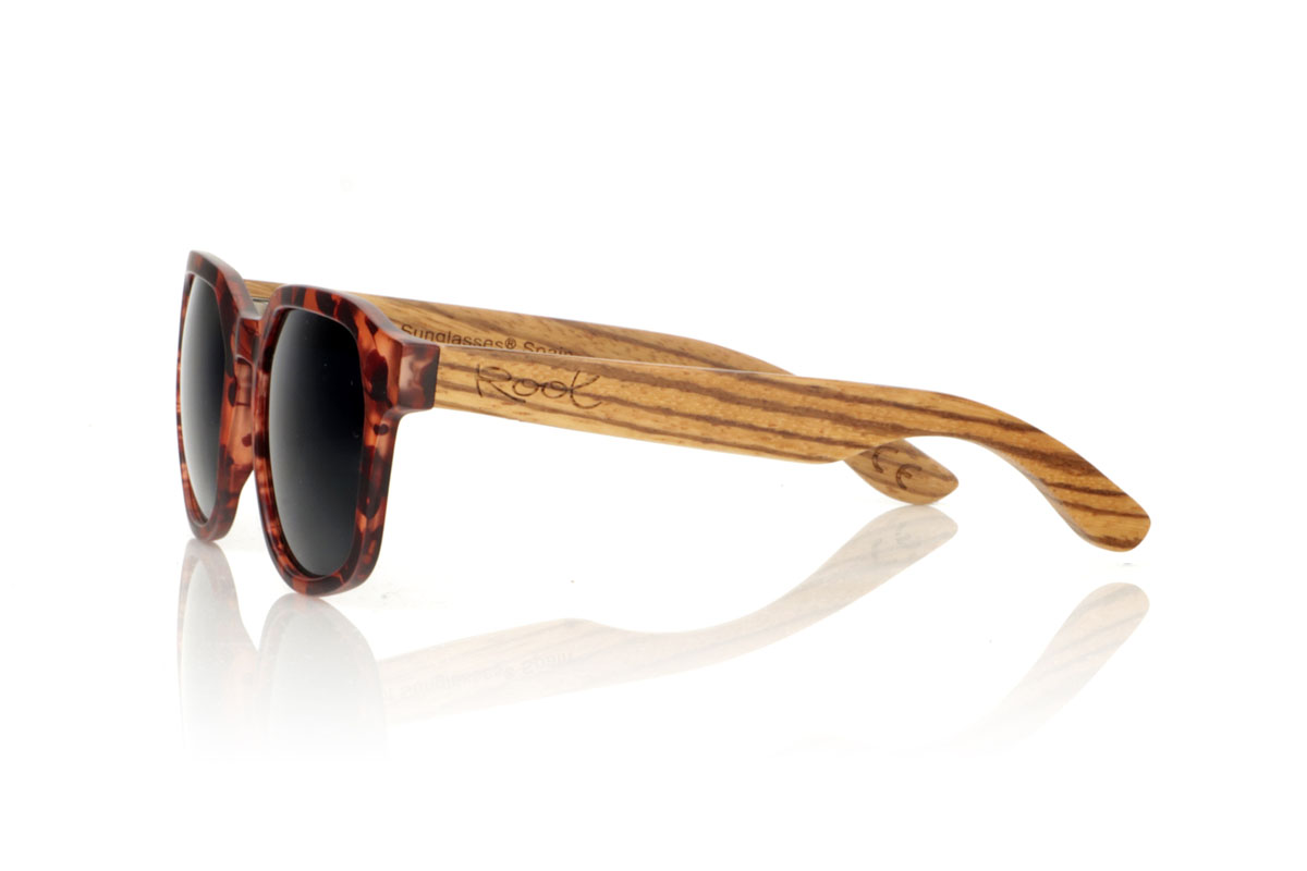 Wood eyewear of Zebrano MOON CAREY. MOON CAREY are everything you need to give an interesting twist to your routine. With their tortoiseshell frames in matte brown and black tones and hexagonal shape, these glasses capture the essence of everyday style. The special part comes with the Zebrano wood shafts, whose unique grain ensures that no two pairs are the same. Comfortable, with total protection and perfect for any adventure under the sun. They are a basic with an extra touch. Give your look that something special. Front measurement: 148x50mm. Caliber: 53. for Wholesale & Retail | Root Sunglasses® 
