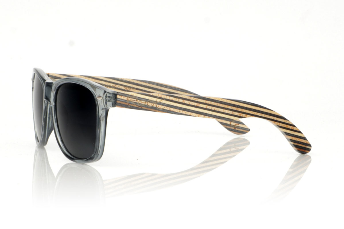 Wood eyewear of Maple SKA MIDNIGHT. SKA MIDNIGHT sunglasses, a modern twist on the classics. Its satin transparent gray  frame captures that urban vibe we all love, while the skateboard-style maple temples show off layers with natural and dark blue tones. Perfect for those who value originality and sustainability in every aspect of their life. SKA MIDNIGHT are not just glasses, they are a statement of principles. Front measurement of 150x47 mm and caliber of 52. for Wholesale & Retail | Root Sunglasses® 