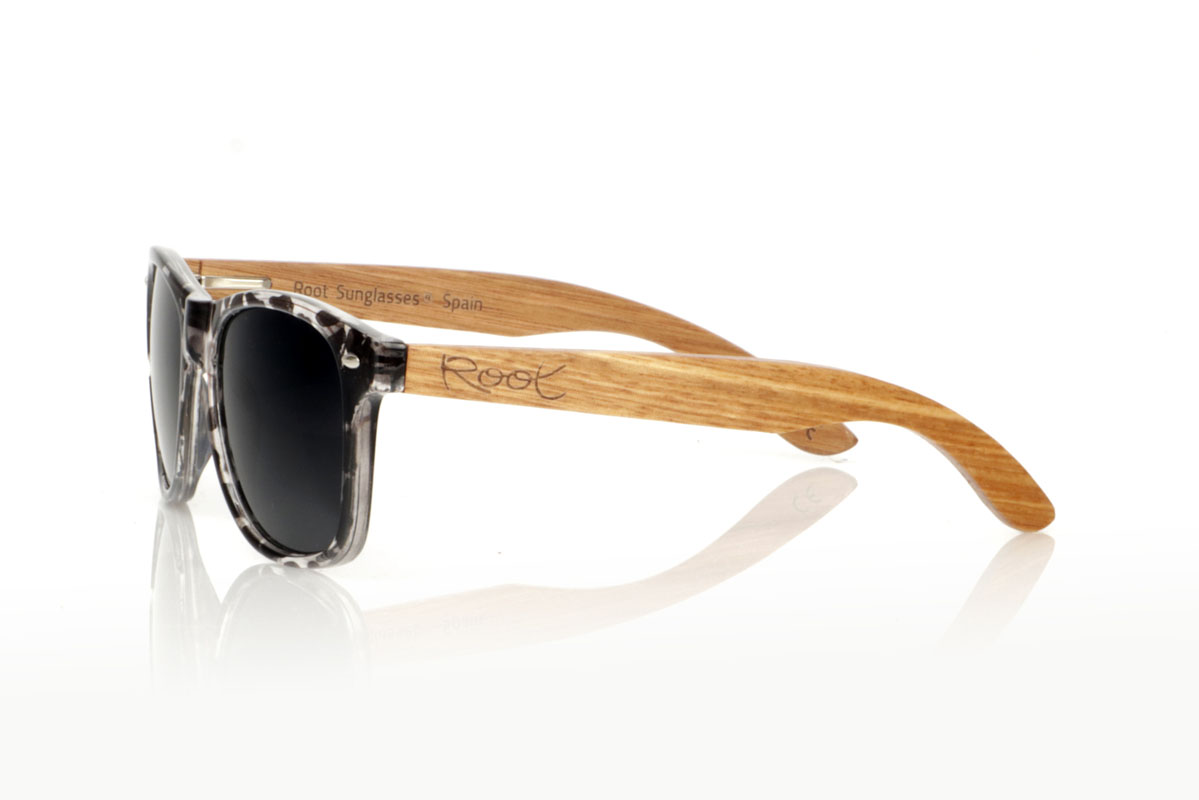 Wood eyewear of Walnut KHUN. KHUN are the new must-have for sunglasses lovers. With its design inspired by the classics, these glasses feature a transparent Tortoiseshell frame in a palette of gray and black with a satin gloss finish, bringing a modern mix to an iconic style. The Walnut temples not only contrast beautifully with the frame, but also add a touch of warmth and naturalness. Perfect for any occasion, the KHUN offers clear vision and protection without compromising style. With measurements of 152x49 and a caliber of 54, they fit perfectly, promising comfort and an impeccable look to those who wear them. for Wholesale & Retail | Root Sunglasses® 