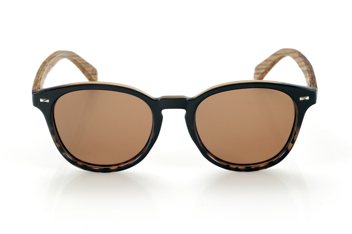 Wood eyewear of Zebrano TANE. TANE wooden sunglasses fuse classic and artisanal. Their vintage-inspired frames in Carey acetate provide a sophisticated and versatile style, while their Zebrano wood temples provide a warm and organic character, highlighting the natural beauty of the material. Thanks to their rounded and timeless design, these glasses adapt to a wide variety of faces, offering a balanced look with a touch of personality. Their high-quality polarized lenses guarantee total protection against UV rays, providing visual comfort in any environment.
Dimensions 142x52mm. Caliber 50, for Wholesale & Retail | Root Sunglasses® 