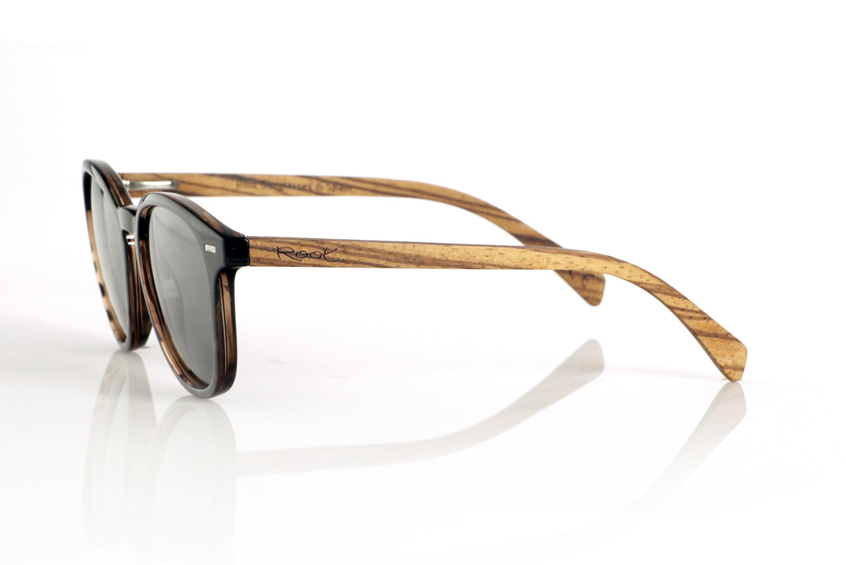 Wood eyewear of Zebrano TANE. TANE wooden sunglasses fuse classic and artisanal. Their vintage-inspired frames in Carey acetate provide a sophisticated and versatile style, while their Zebrano wood temples provide a warm and organic character, highlighting the natural beauty of the material. Thanks to their rounded and timeless design, these glasses adapt to a wide variety of faces, offering a balanced look with a touch of personality. Their high-quality polarized lenses guarantee total protection against UV rays, providing visual comfort in any environment.
Dimensions 142x52mm. Caliber 50, for Wholesale & Retail | Root Sunglasses® 
