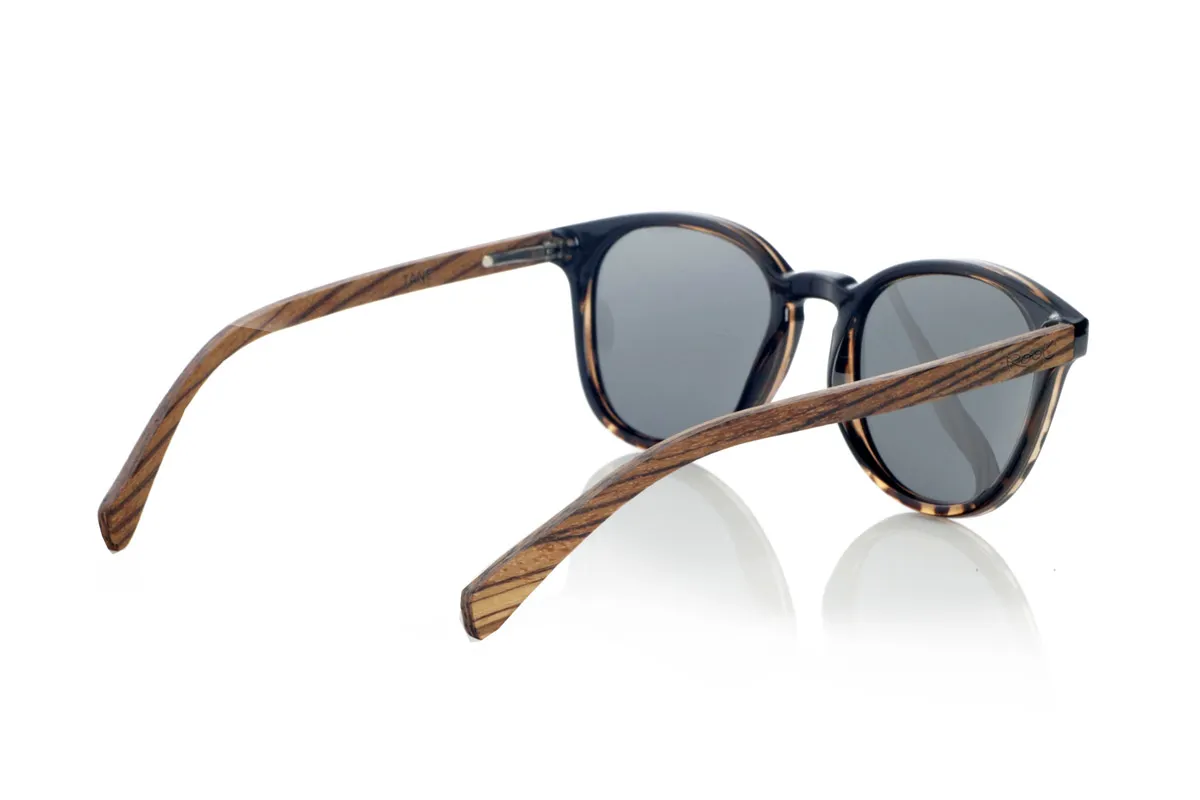 Gafas de Madera Natural de Zebrano TANE. Las gafas de madera TANE fusionan lo clásico y lo artesanal. Su montura de inspiración vintage en acetato Carey aporta un estilo sofisticado y versátil, mientras que sus varillas de madera de Zebrano aportan un carácter cálido y orgánico, resaltando la belleza natural del material. Gracias a su diseño redondeado y atemporal, estas gafas se adaptan a una gran variedad de rostros, ofreciendo un look equilibrado con un toque de personalidad. Sus lentes polarizadas de alta calidad garantizan protección total contra los rayos UV, aportando comodidad visual en cualquier entorno.
Dimensiones de 142x52mm. Calibre de 50, Venta al Por Mayor y Detalle | Root Sunglasses® 