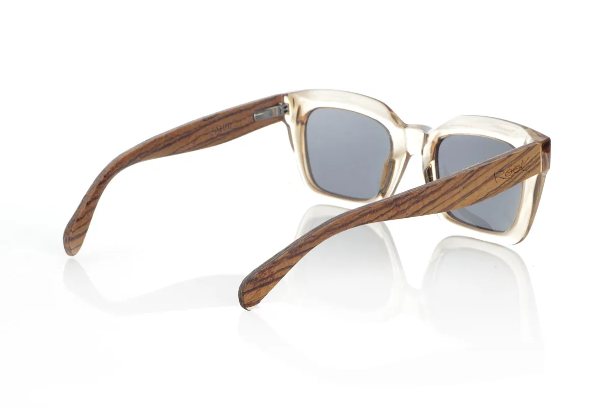 Gafas de Madera Natural de Zebrano ZAHIR. Las ZAHIR combinan un diseño robusto y sofisticado con la esencia natural de la madera. Su montura en acetato translúcido en tono ámbar aporta un toque moderno y elegante, mientras que sus varillas de madera de Zebrano destacan por su veteado único, resaltando la autenticidad de cada pieza. Estas gafas de sol de madera no solo ofrecen estilo, sino también funcionalidad, con lentes polarizadas de alta calidad que garantizan protección total contra los rayos UV. Ideales para quienes buscan un equilibrio entre diseño contemporáneo y materiales naturales.

Dimensiones de 147x50mm. Calibre de 50. Venta al Por Mayor y Detalle | Root Sunglasses® 