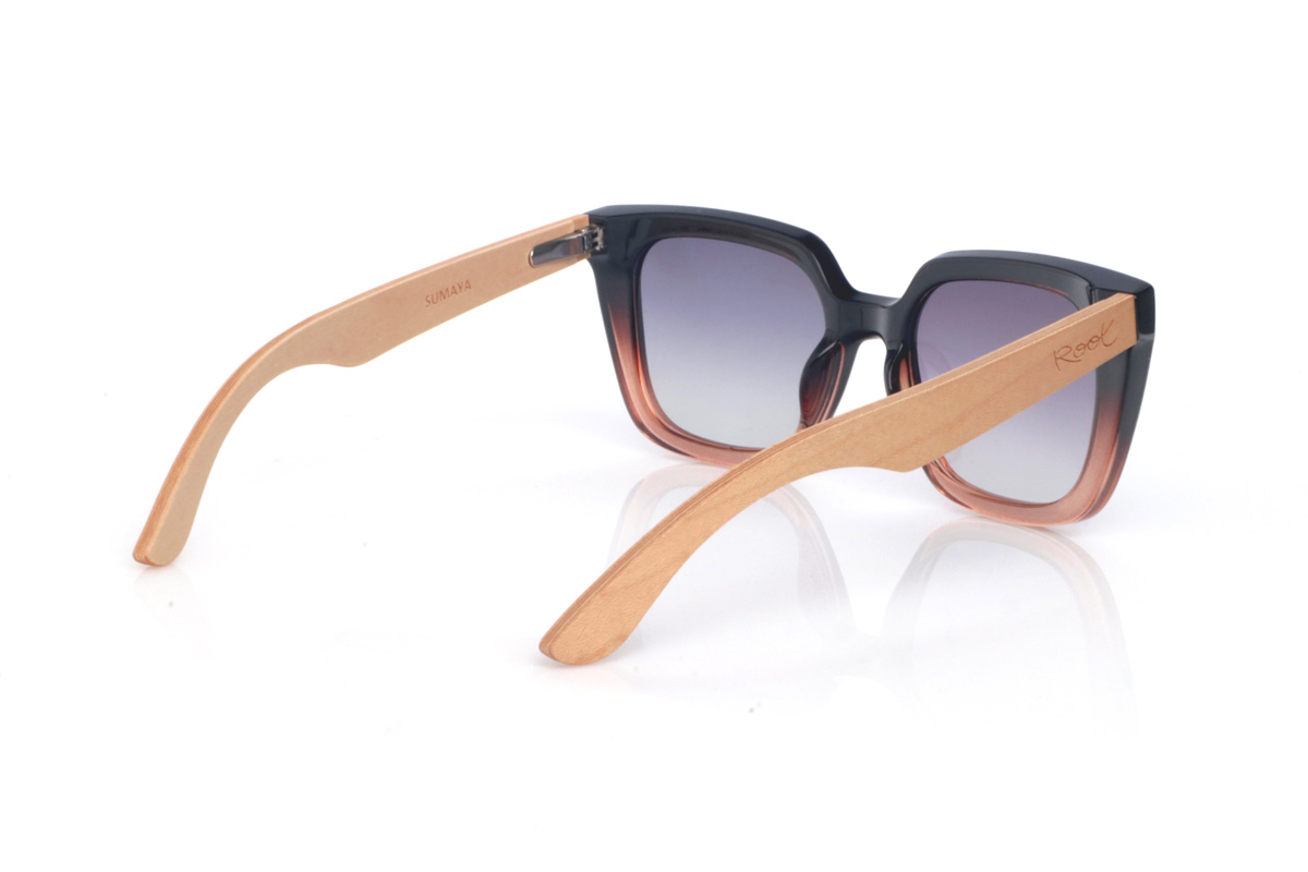 Wood eyewear of Maple SUMAYA. The SUMAYA wooden sunglasses stand out with an oversized, squared silhouette with a subtle cat-eye touch that’s flattering and full of presence. The finish blends a soft black on the upper part with a translucent gradient in rosy/amber tones at the base, creating a stylish, modern contrast.

Maple wood temples add visual lightness and a natural touch that balances the design, with a clean, comfortable profile for everyday wear. A perfect choice if you’re looking for a bold, feminine look that’s easy to match.

Dimensions: 145x42
Calibre: 50
 for Wholesale & Retail | Root Sunglasses® 