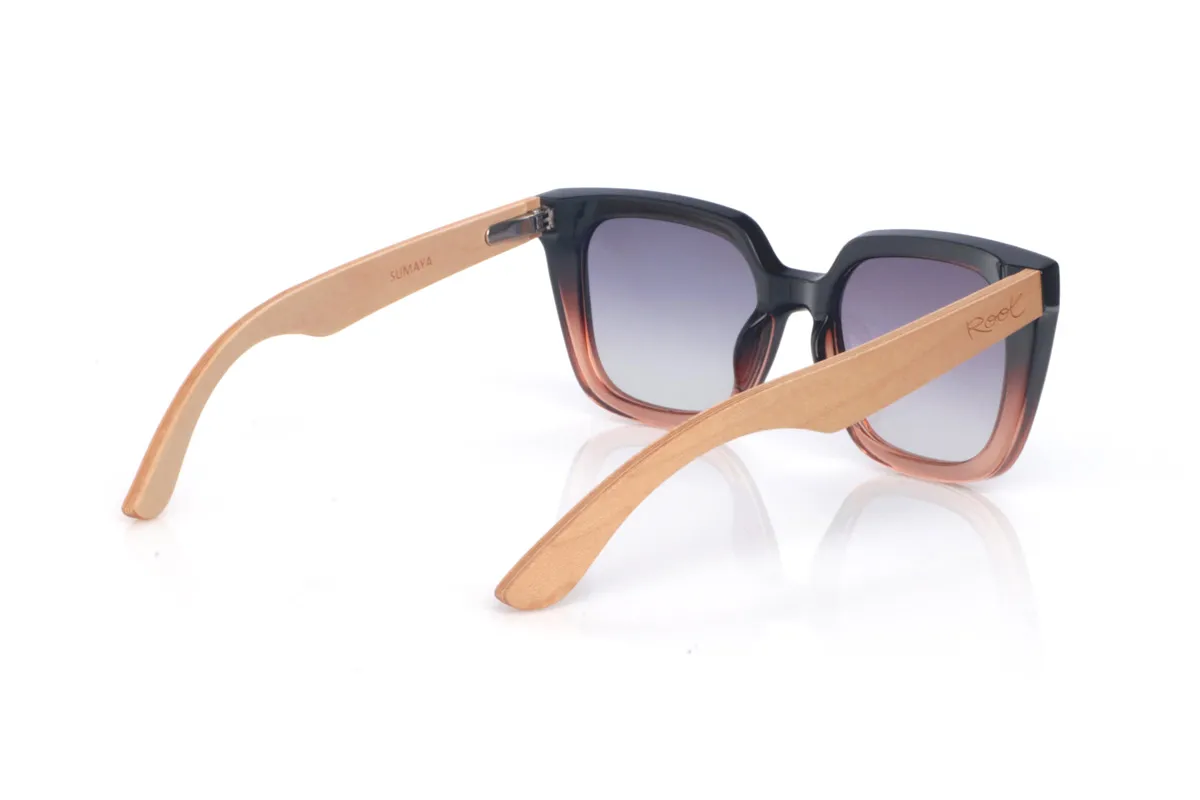 Wood eyewear of Maple SUMAYA. The SUMAYA wooden sunglasses stand out with an oversized, squared silhouette with a subtle cat-eye touch that’s flattering and full of presence. The finish blends a soft black on the upper part with a translucent gradient in rosy/amber tones at the base, creating a stylish, modern contrast.

Maple wood temples add visual lightness and a natural touch that balances the design, with a clean, comfortable profile for everyday wear. A perfect choice if you’re looking for a bold, feminine look that’s easy to match.

Dimensions: 145x42
Calibre: 50
 for Wholesale & Retail | Root Sunglasses® 