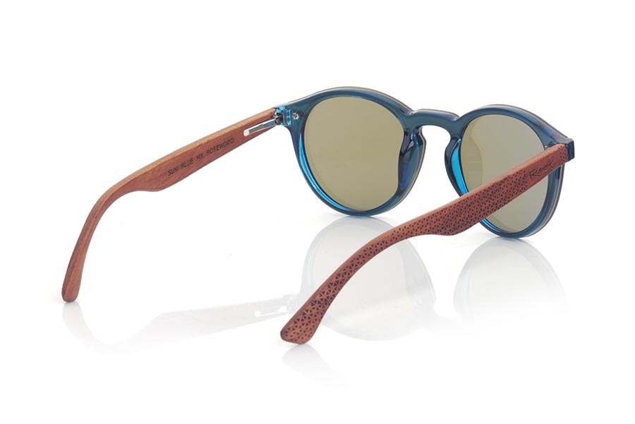 Gafas de Madera Natural de ROSEWOOD SUN BLUE. Las gafas de sol SUN BLUE están realizadas con el frontal de material sintético azul y las varillas en madera de palisandro grabadas con un patrón étnico, se trata de un modelo femenino redondeado muy de tendencia actual, las lentes planas <b>PC NO POLARIZADAS</b> cubren todo el frontal. Medida frontal: 136X49mm Venta al Por Mayor y Detalle | Root Sunglasses® 