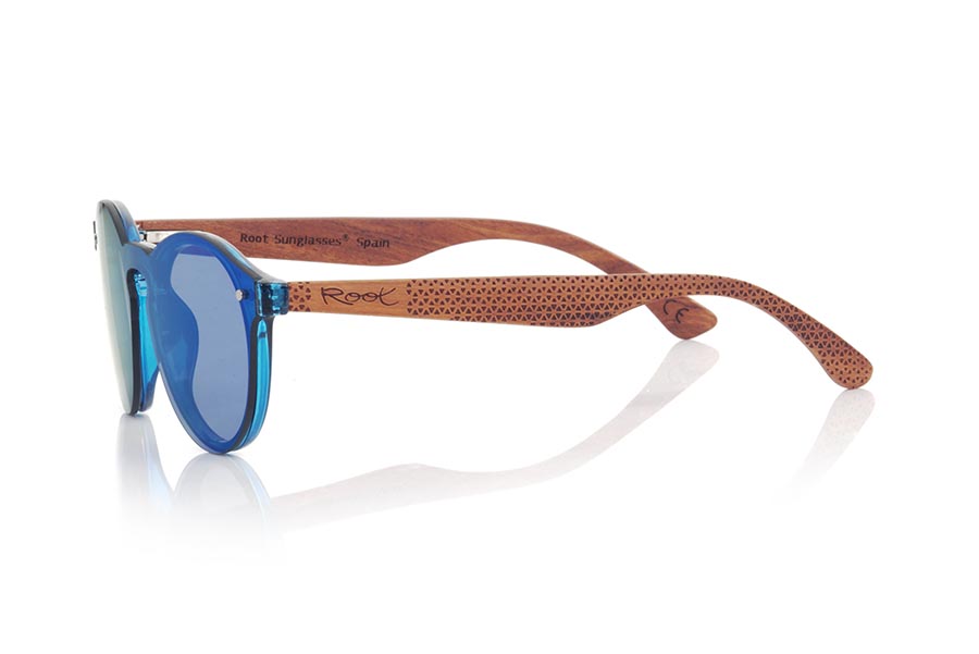 Gafas de Madera Natural de ROSEWOOD SUN BLUE. Las gafas de sol SUN BLUE están realizadas con el frontal de material sintético azul y las varillas en madera de palisandro grabadas con un patrón étnico, se trata de un modelo femenino redondeado muy de tendencia actual, las lentes planas <b>PC NO POLARIZADAS</b> cubren todo el frontal. Medida frontal: 136X49mm Venta al Por Mayor y Detalle | Root Sunglasses® 