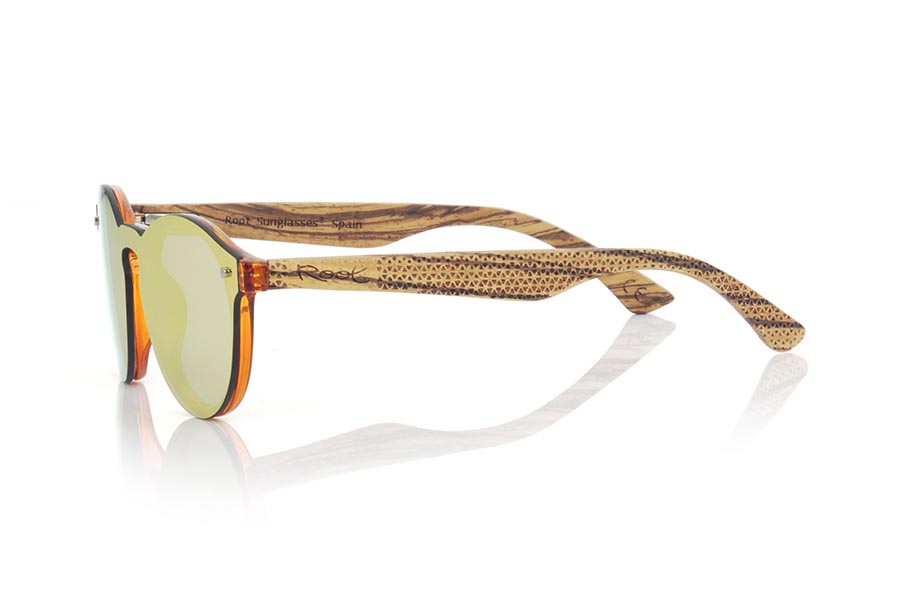 Gafas de Madera Natural de  SUN ORANGE. Las gafas de sol SUN ORANGE están realizadas con el frontal de material sintético naranja trnsparente y las varillas en madera de zebra grabadas con un patrón étnico, se trata de un modelo femenino redondeado muy de tendencia actual, las lentes planas <b>PC NO POLARIZADAS</b> cubren todo el frontal. Medida frontal: 136X49mm Venta al Por Mayor y Detalle | Root Sunglasses® 