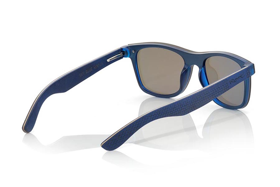 Gafas de Madera Natural de Laminada SKY BLUE. Las gafas de sol SKY BLUE están realizadas con el frontal de material sintético azul transparente y las varillas en madera de skateboard de arce laminada grabadas con un patrón étnico, se trata de un modelo de última tendencia, las lentes planas <b>PC NO POLARIZADAS</b> cubren todo el frontal. Medida frontal: 152X48mm Venta al Por Mayor y Detalle | Root Sunglasses® 