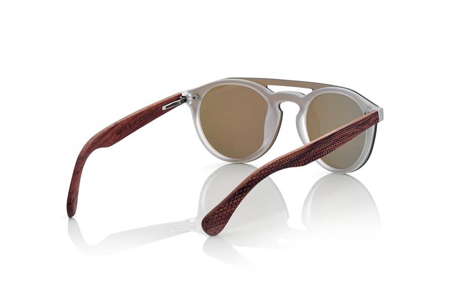 Gafas de Madera Natural de ROSEWOOD SAMBA BLUE. Las gafas de sol SAMBA BLUE están realizadas con el frontal de material sintético TRANSLÚCIDO y las varillas en madera de PALISANDRO grabadas con un patrón étnico, se trata de un modelo femenino redondeado muy de tendencia actual las lentes planas <b>PC NO POLARIZADAS</b> cubren todo el frontal.. Medida frontal: 137X49mm Venta al Por Mayor y Detalle | Root Sunglasses® 