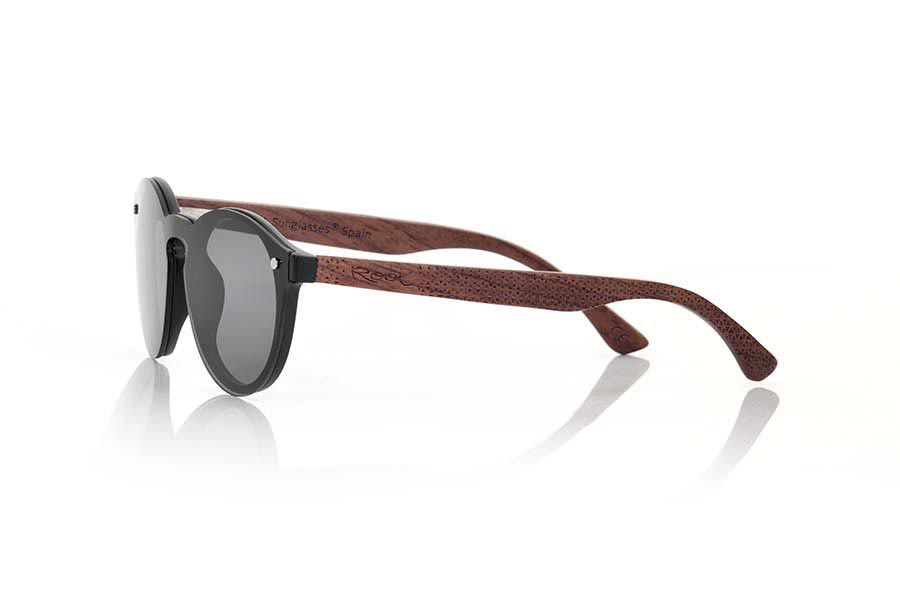 Gafas de Madera Natural de Palisandro SUN BLACK. Las gafas de sol SUN BLACK están realizadas con el frontal de material sintético negro y las varillas en madera de palisandro grabadas con un patrón étnico, se trata de un modelo femenino redondeado muy de tendencia actual las lentes planas <b>PC NO POLARIZADAS</b> cubren todo el frontal.. Medida frontal: 136X49mm Venta al Por Mayor y Detalle | Root Sunglasses® 