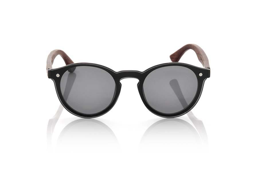 Gafas de Madera Natural de Palisandro SUN BLACK. Las gafas de sol SUN BLACK están realizadas con el frontal de material sintético negro y las varillas en madera de palisandro grabadas con un patrón étnico, se trata de un modelo femenino redondeado muy de tendencia actual las lentes planas <b>PC NO POLARIZADAS</b> cubren todo el frontal.. Medida frontal: 136X49mm Venta al Por Mayor y Detalle | Root Sunglasses® 