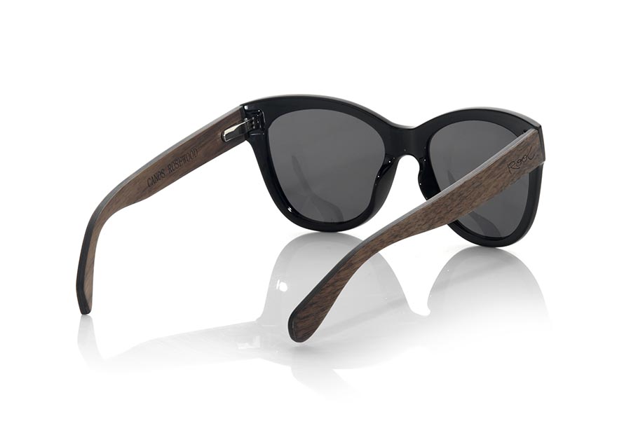 Wood eyewear of Rosewood CANOS. The CANOS sunglasses are made with the front in black PC material and the wooden sideburns of Natural rosewood. Very feminine model of rounded shapes and very fine mount that feels good to all kinds of people, the CANO sunglasses have been combined  with several lenses colors. Frontal measurement: 142x55mm for Wholesale & Retail | Root Sunglasses® 