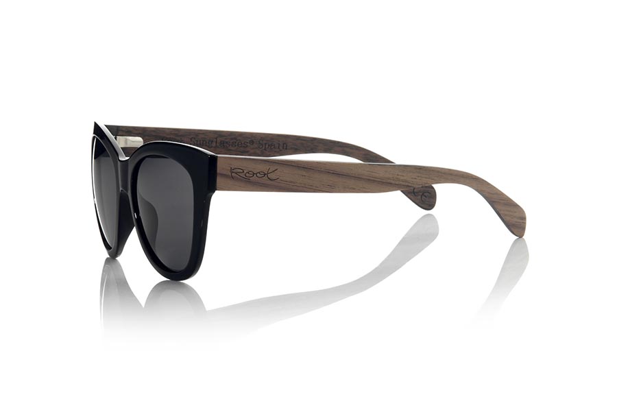 Wood eyewear of Rosewood CANOS. The CANOS sunglasses are made with the front in black PC material and the wooden sideburns of Natural rosewood. Very feminine model of rounded shapes and very fine mount that feels good to all kinds of people, the CANO sunglasses have been combined  with several lenses colors. Frontal measurement: 142x55mm for Wholesale & Retail | Root Sunglasses® 