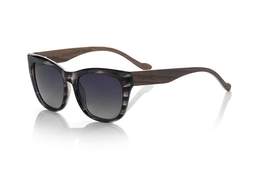 Wood eyewear of Walnut modelo ESPARTEL. The ESPARTEL sunglasses are made with the front in marbel black PC material and NOGAL Natural wood legs. Very feminine model of suggestive shapes, the ESPARTEL sunglasses have been combined as standard with several lenses. Front measurement: 145x52mm | Root Sunglasses®