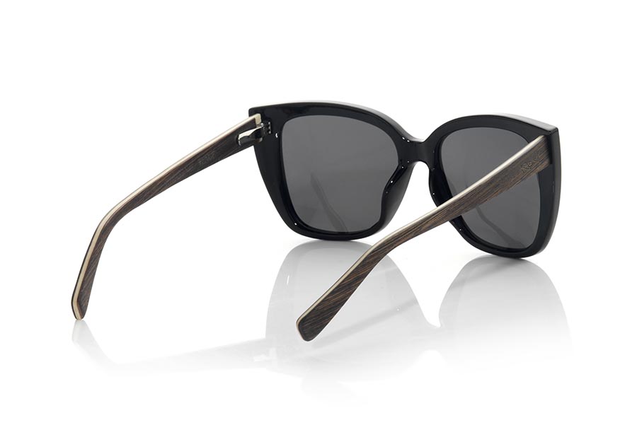 Wood eyewear of Wenge CAMARINAL. The sunglasses are made with the front in glossy black PC material and the Natural WENGE wood sideburns. Very feminine model of suggestive shapes inspired IN the CAMARINAL cape , the sunglasses CAMARINAL have been combined in series with several lenses. Frontal measurement: 145x55mm for Wholesale & Retail | Root Sunglasses® 