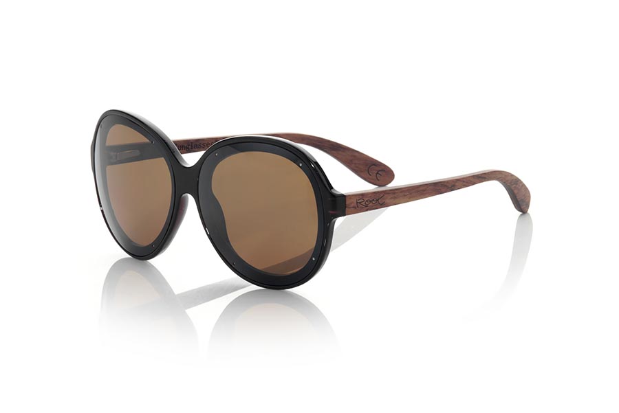 Wood eyewear of Rosewood GUADALMESI. The sunglasses GUADALMESI are made with the front in PC material of glossy black color and the wooden sideburns of rosewood Natural. Very feminine model of suggestive forms inspired by the beaches of GUADALMESI in TARIFA, the GUADALMESI sunglasses have been combined with several lenses. Frontal measurement: 147x60mm for Wholesale & Retail | Root Sunglasses® 