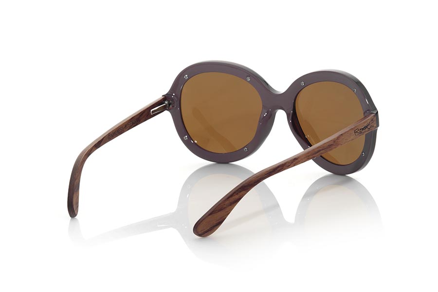 Wood eyewear of Rosewood GUADALMESI. The sunglasses GUADALMESI are made with the front in PC material of glossy black color and the wooden sideburns of rosewood Natural. Very feminine model of suggestive forms inspired by the beaches of GUADALMESI in TARIFA, the GUADALMESI sunglasses have been combined with several lenses. Frontal measurement: 147x60mm for Wholesale & Retail | Root Sunglasses® 