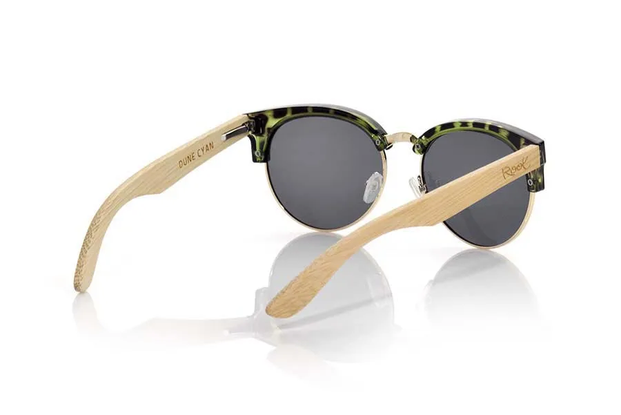 Wood eyewear of Bamboo DUNE CYAN. DUNE CYAN sunglasses are made with carey green cyan plastic front and sideburns in natural bamboo wood, open front, metal bridge and adjustable nose pads combined with four colors of lenses that will adapt perfectly to your taste and to your modern style. Measure front: 139X49mm for Wholesale & Retail | Root Sunglasses® 