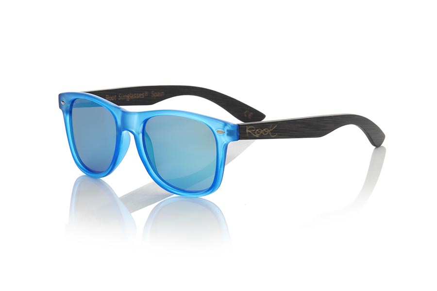 Wood eyewear of Bamboo modelo SUN BLUE MX. SUN BLUE MX sunglasses are manufactured with the front panel transparent matte blue synthetic material and natural bamboo wood pins combined with four colors of lenses that allow you to adapt to your style. Front size: 145x48mm | Root Sunglasses® 