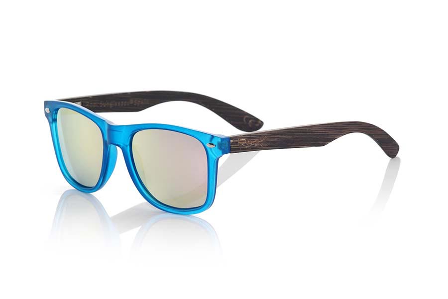 Wood eyewear of Bamboo modelo SUN BLUE MX. SUN BLUE MX sunglasses are manufactured with the front panel transparent matte blue synthetic material and natural bamboo wood pins combined with four colors of lenses that allow you to adapt to your style. Front size: 145x48mm | Root Sunglasses®