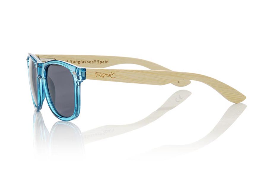 Wood eyewear of Bamboo CANDY BLUE. The Candy Blue sunglasses are made with sinthetic front in blue transparent and sideburns in natural bamboo combined with four lens colors that will adapt perfectly to your taste and your modern style. Front Measure: 148x50mm for Wholesale & Retail | Root Sunglasses® 