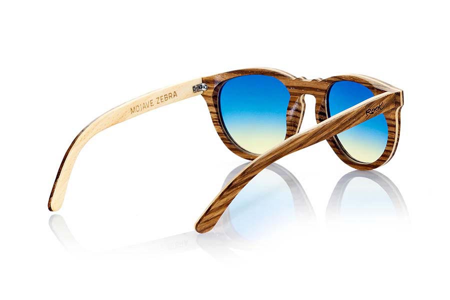 Wood eyewear of Zebrano MOJAVE. Mojave sunglasses are manufactured in Zebrano wood and maple. Zebrano wood is interspersed with a thin sheet of maple that gives this frame a very unique touch hardwood. CR39 lenses are combined with degraded blue or brown, rounded mount feel good to people whose tastes match such forms. The Sirius will surprise you with its combination of woods. Dimensions: 144x54mm for Wholesale & Retail | Root Sunglasses® 