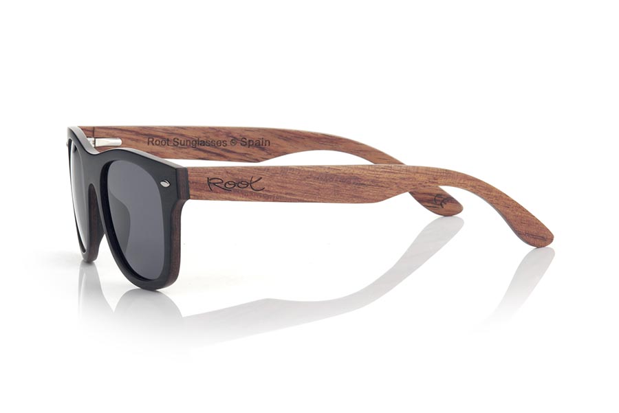 Gafas de Madera Natural de Ébano ITACA. Las nuevas gafas de sol Itaca están fabricadas en madera de Ébano y madera de Palisandro (Rosewood) laminadas combinadas, el Frontal de las Itaca es de madera de ébano con una lámina de madera de palisandro intercalada a modo de sándwich mientras que las varillas están completamente realizadas en madera de palisandro es un modelo de líneas clásicas y un tamaño optimizado en el montamos de serie 3 tipos de lentes Grises. Te sorprenderá la combinación de maderas su cuidada terminación, su forma y la variedad de lentes disponibles. Medida frontal: 143x47mm Venta al Por Mayor y Detalle | Root Sunglasses® 