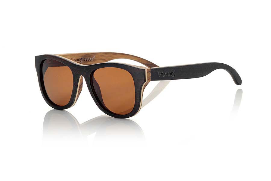 Gafas de Madera Natural de Wenge SECHURA. Las gafas de sol Sechura están fabricadas en madera de Wenge, Arce y Zebra combinadas. El frontal de las Sechura es de madera de Wenge en la parte exterior y madera de zebra en el interior el frontal lleva intercalada una capara fina de madera de arce clara. Por su parte las patillas están fabricadas con madera de Wenge en el exterior y zebrano en el interior. Te sorprenderá la calidad de esta montura y la combinación de maderas. Vienen de serie con lentes Marrones grises o Naranja REVO. Medida frontal: 143x47mm  Venta al Por Mayor y Detalle | Root Sunglasses® 