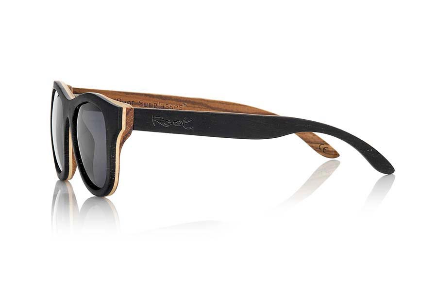 Gafas de Madera Natural de Wenge SECHURA. Las gafas de sol Sechura están fabricadas en madera de Wenge, Arce y Zebra combinadas. El frontal de las Sechura es de madera de Wenge en la parte exterior y madera de zebra en el interior el frontal lleva intercalada una capara fina de madera de arce clara. Por su parte las patillas están fabricadas con madera de Wenge en el exterior y zebrano en el interior. Te sorprenderá la calidad de esta montura y la combinación de maderas. Vienen de serie con lentes Marrones grises o Naranja REVO. Medida frontal: 143x47mm  Venta al Por Mayor y Detalle | Root Sunglasses® 