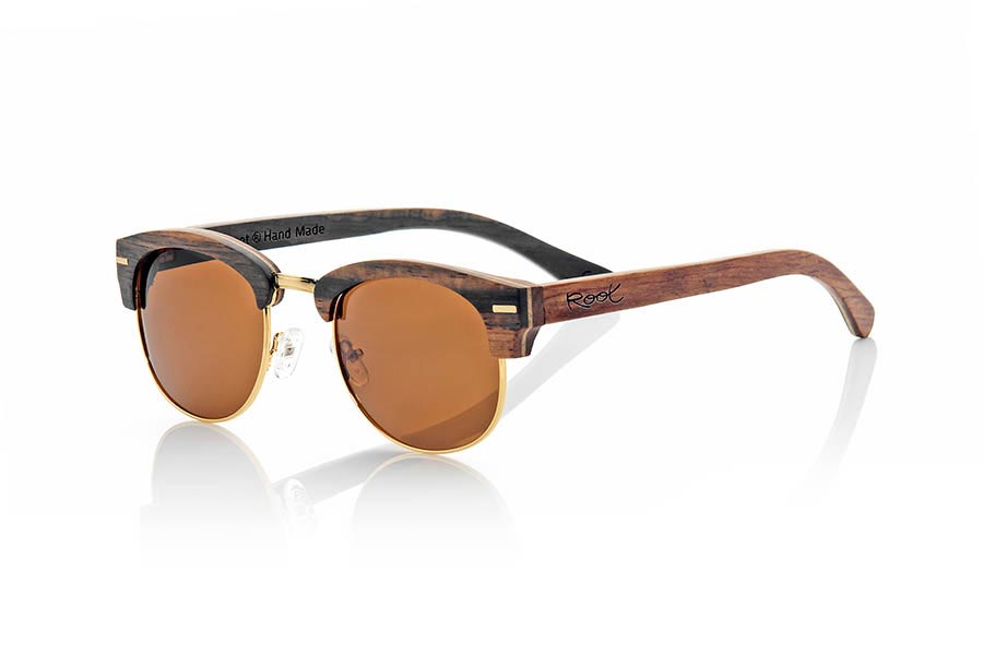 Gafas de Madera Natural de Ébano ICARO. Las gafas de sol ICARO están fabricadas en una combinación de tres maderas, ébano, arce y palisandro combinadas en diferentes capas. el frontal se presenta en madera de ébano una capa intermedia de madera de arce y la parte interior en madera de palisandro mientras que en las varillas se invierte este patrón quedando la madera de palisandro en la parte exterior y la madera de ébano en el interior. Se trata de un modelo unisex abierto con el aro inferior y puente dorado y pads para la nariz ajustables de un tamaño estándar que se adapta a todo tipo de caras y personas. Las hemos combinado con varios tipos de lentes PC. Medida frontal: 143x46mm Venta al Por Mayor y Detalle | Root Sunglasses® 