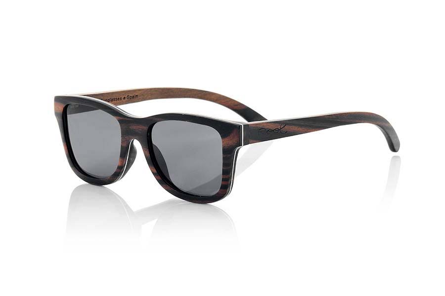 Gafas de Madera Natural de Ébano DANAKIL. Las gafas de sol DANAKIL están realizadas en madera de ébano maciza con una fina lámina de aluminio intercalada en la montura lo que aporta a este modelo, además de un atractivo toque metálico en el lateral que combinado con esta preciosa madera le confiere un plus de elegancia, un extra de resistencia y permite que la montura sea más fina quedando en aproximadamente 4,5mm de espesor. Las DANAKIL son un modelo algo sobre dimensionado queda estupendamente en cara anchas o más redondas. Te sorprenderá la belleza de la madera su elegante toque metálico en los laterales y su montura fina. Las gafas de sol DANAKIL incluyen  un práctico estuche plegable que mantiene tus gafas seguras cuando están en su interior y ocupa muy poco espacio cuando está plegado.  Medida frontal: 147x50mm Venta al Por Mayor y Detalle | Root Sunglasses® 